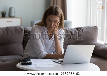 Concerned woman thinks over high domestic utility, huge electricity tariffs looks at laptop reviewing bank statement feels stressed due lack of money to pay bills. Expenses, financial problem Royalty-Free Stock Photo #2187282163