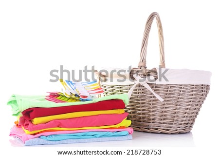 Bright clothes and empty wicker basket, isolated on white