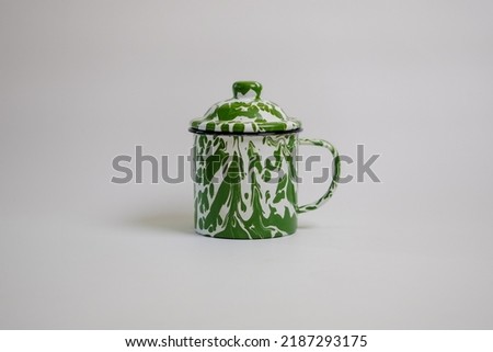 White and Green Tye Dye Vintage Mug on the Isolated Background. An Enamel Mug that usually available on Indonesian Parents House.  Royalty-Free Stock Photo #2187293175