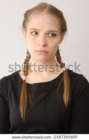 Portrait of sad or serious young woman in studio