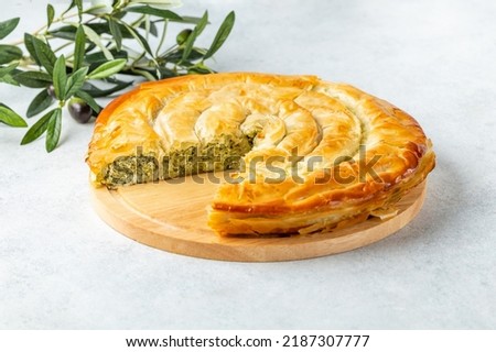 Traditional feta cheese phyllo pastry pie. Light background. 
