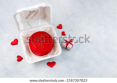 Plastic lunch box with tasty bento cake and gifts for Valentine's Day on white background