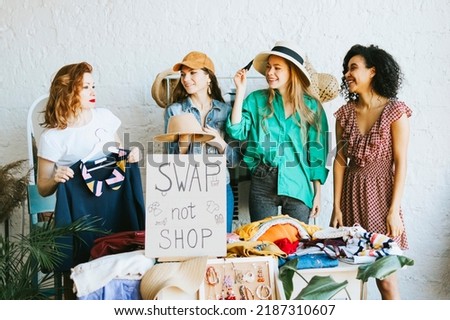 four young woman female caucasian and african students at swap party try on clothes, bags, shoes and accessories, change clothes with each other, second hand for things, zero waste life, eco-friendly Royalty-Free Stock Photo #2187310607