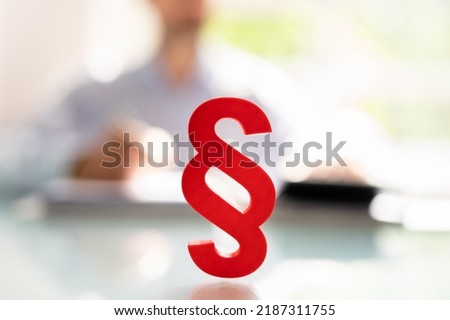 Close-up Of A Red Paragraph Symbol In Front Of Person Working At Workplace Royalty-Free Stock Photo #2187311755
