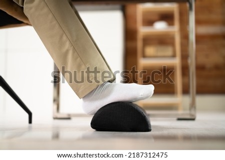 Footrest Against Pain In Office. Shifting Posture And Positions Royalty-Free Stock Photo #2187312475