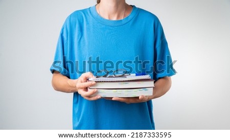 Glasses, notebooks, books in the hands of the student on a white background - training in courses and lessons. High quality photo