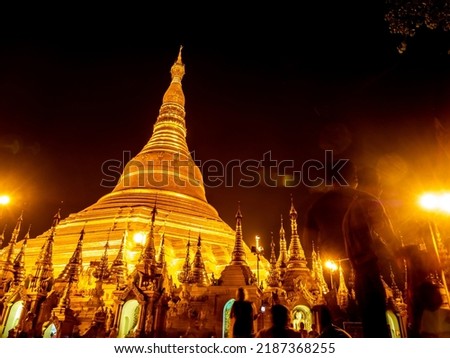 Lens Flare in the picture of group of golden pagodas and mondops are illuminated in the light of the night Royalty-Free Stock Photo #2187368255