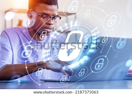 Black businessman student working with laptop, security lock chain and glowing hologram with digital icons. Concept of privacy and data protection Royalty-Free Stock Photo #2187375063
