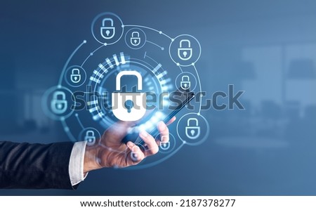 Businessman with smartphone in hand. Cybersecurity hud hologram with glowing lock circuit, office blurred background. Concept of cybersecurity and technology