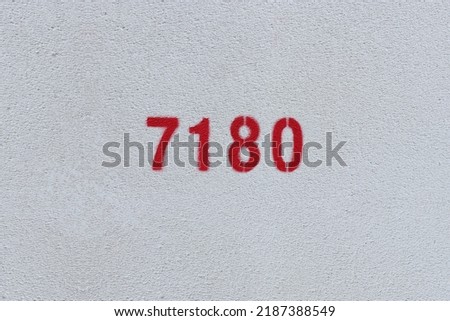 Red Number 7180 on the white wall. Spray paint.
