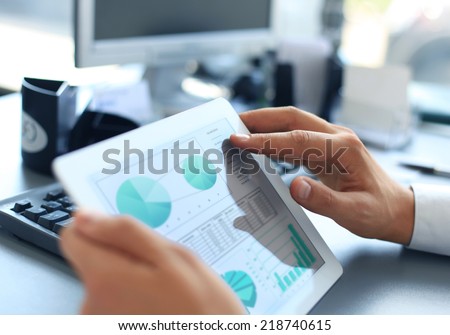Business person analyzing financial statistics displayed on the tablet screen  Royalty-Free Stock Photo #218740615