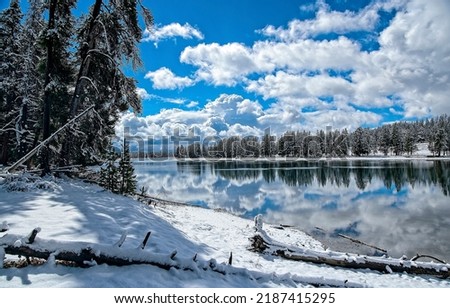 Clouds over the river in the winter snow forest. River reflection in winter snow forest. Winter river in snowy forest. Winter river landscape Royalty-Free Stock Photo #2187415295