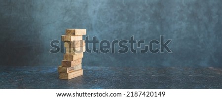 Wooden block stack concept of prevent collapse or crash of financial business and risk management or strategic planning and insurance. Royalty-Free Stock Photo #2187420149