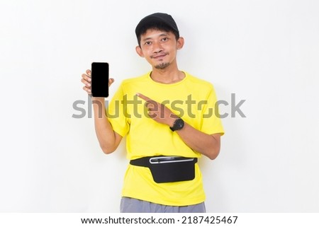 asian sport man hold mobile phone with blank empty screen isolated on white background
