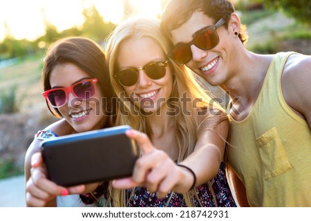Outdoor portrait of group of friends taking a self portrait in the park.