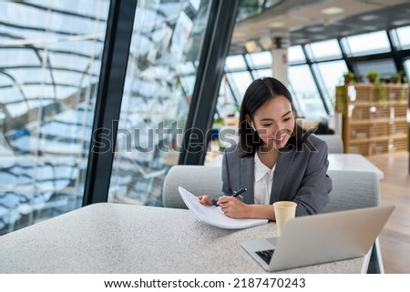 Young Asian business woman employee or executive manager using computer looking at laptop and talking leading hybrid conference remote video call virtual meeting or online interview working in Royalty-Free Stock Photo #2187470243