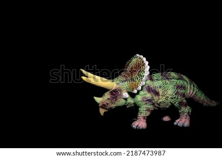 Toy herbivore dinosaur on a black background. Toy Triceratops Royalty-Free Stock Photo #2187473987