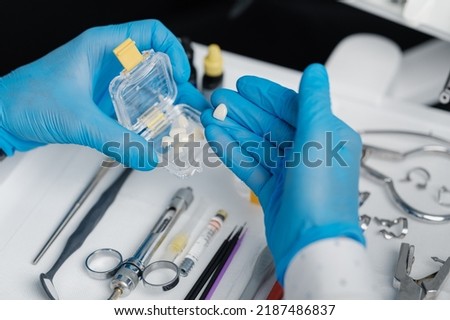 Transparent transportation box with veneers made of pressed ceramics in hands of orthodontist in a dental office Royalty-Free Stock Photo #2187486837