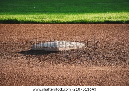 Second base bag on baseball field with outfield grass in distance