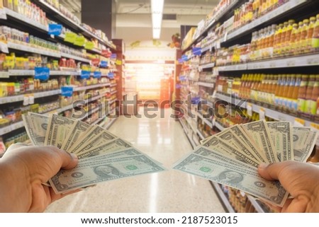 A hand holding dollars on shop. A man holding dollars for cash  on product background.Money for sales exchange. Photo concept  finances and money.