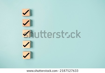 Black correct sign and tick check mark to wooden cube block with copy space for checklist of ISO quality control and approve business product concept.