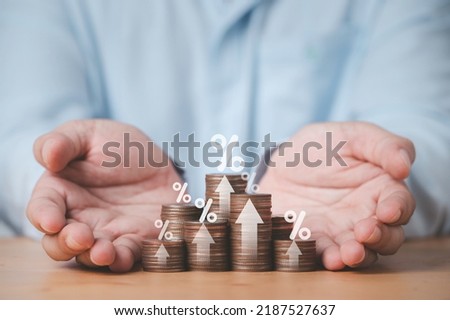 Two hand giving heap of coins money with up arrow and percentage symbol for financial banking increase interest rate or mortgage investment dividend from business growth concept. Royalty-Free Stock Photo #2187527637
