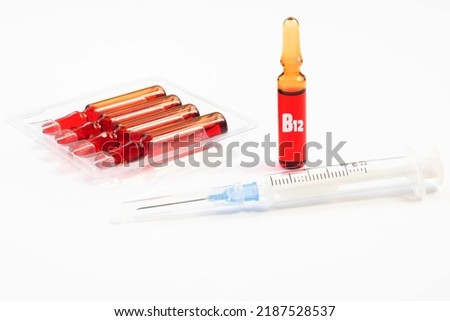 Injection of vitamins B 12 on a white background. Ampoules with red liquid. Beauty and health concept. Copy space. Selective focus Royalty-Free Stock Photo #2187528537