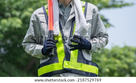 Work clothes and water.Workers to prevent heat stroke.Red stick and security guard uniform.