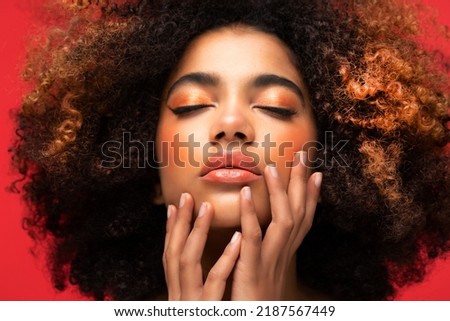Pleased dark skinned attractive young female model with bushy Afro hairstyle closes eyes, spends free time alone, has broad smile. People, leisure and happiness concept. Royalty-Free Stock Photo #2187567449