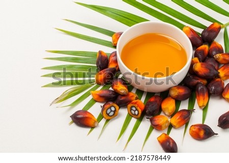 palm oil in a bowl with palm fruits and leaf.