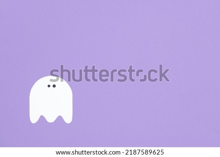 Trendy minimalist halloween background, white cute ghost isolated on lilac, pastel color design with copy space.