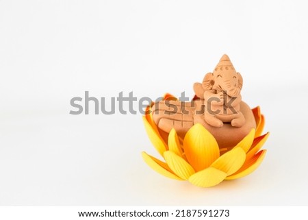 Lord Ganesha sculpture with flower on white background, Hindu lord