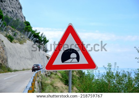 road sign announcing a tunnel in the mountains