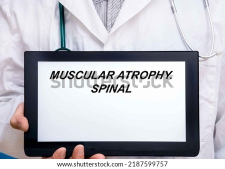 Muscular Atrophy.  Doctor with rare or orphan disease text on tablet screen Muscular Atrophy Royalty-Free Stock Photo #2187599757
