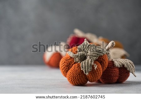  Knitted handmade pumpkins on a grey background. Autumn and coziness. DIY decor.