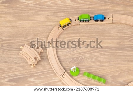 eco wooden toy train tracks for toddlers with cars arranged chaotic on laminate floor.activities for baby,kids.intelligent building blocks.train railway set.police car,autobus.direction sign,left turn