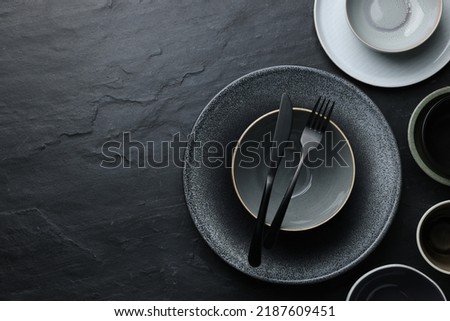 Set of clean tableware on black table, flat lay. Space for text Royalty-Free Stock Photo #2187609451