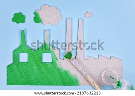 Greenwashing concept with cardboard factory being painted green Royalty-Free Stock Photo #2187632213