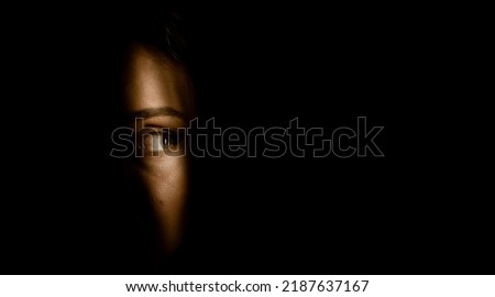 eye emerging from shadows  spying concept Royalty-Free Stock Photo #2187637167