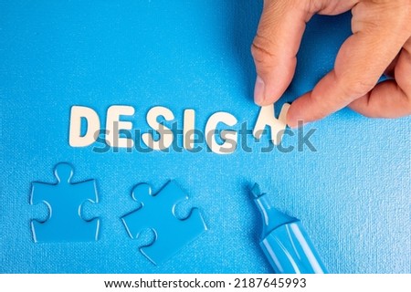 Design. Text from white wooden letters on a blue background.