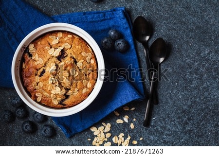 Vegan oatmeal, banana, blueberry mug muffin on blue background, top view. Plant based dessert. Royalty-Free Stock Photo #2187671263