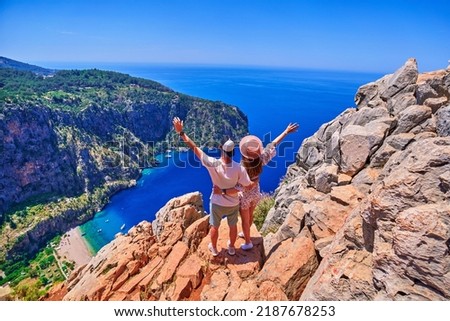 Lovers couple traveler stands together on hill rock over blue sea bay in Turkey, butterfly valley. Enjoy holiday vacation and beautiful traveling places Royalty-Free Stock Photo #2187678253