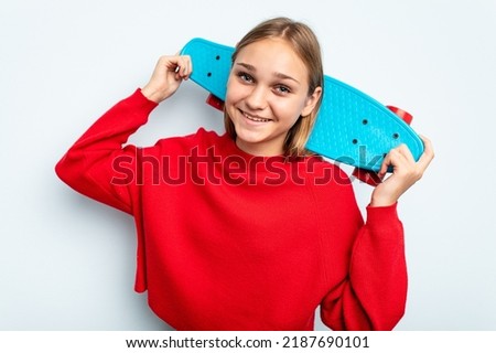 Young skater caucasian girl isolated on blue background