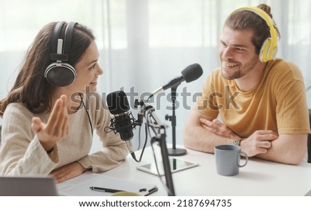 Young man and woman wearing headphones and doing a live podcast for their channel, communication and technology concept