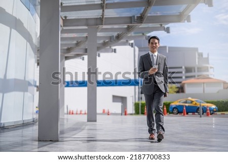 Businessman with smartphone walking against street blurred building background, Fashion business photo of beautiful girl in casual suite with smart phone.