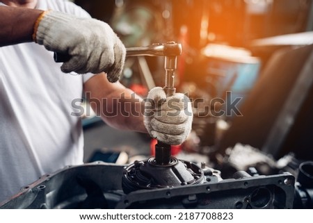 Closeup of auto mechanic are using the wrench to repair and maintenance auto engine is problems at car repair shop.