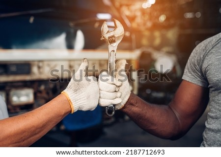 Automobile Master Wearing Gloves Showing Positive Gesture after Finishing Work, Thumb Up and Mechanics Hand with Tool.