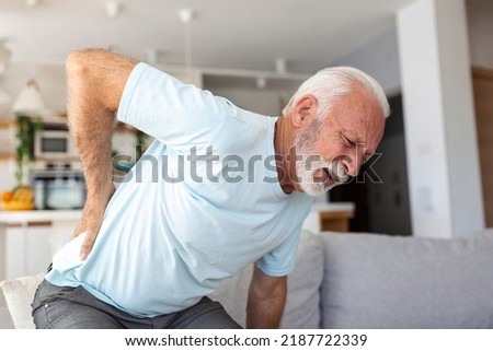 Senior elderly man touching his back, suffering from backpain, sciatica, sedentary lifestyle concept. Spine health problems. Healthcare, insurance Royalty-Free Stock Photo #2187722339