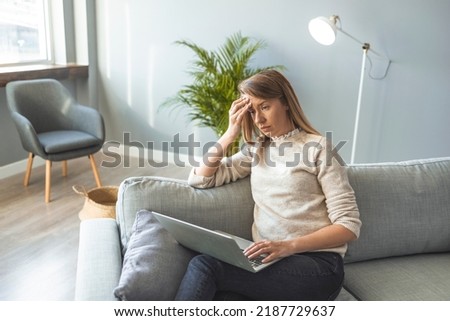 Exhausted young woman suffering from dry eyes syndrome or having painful feelings due to computer overwork, massaging nose bridge, relieving strain. Tired upset woman