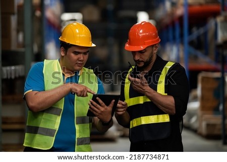 Warehouse workers selling stock checks with tablets .